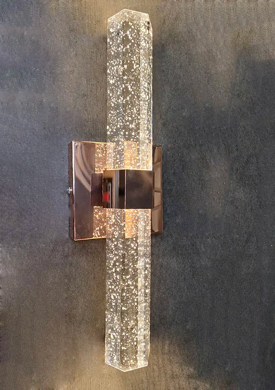 Modern bubble crystal LED wall sconce with a vertical rectangular design mounted on a dark surface.