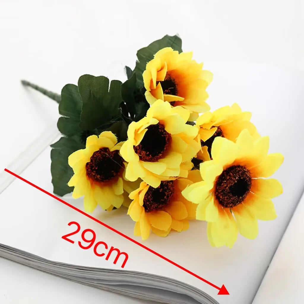 A bouquet of artificial yellow sunflowers displayed on a white surface.