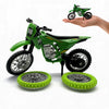 A green 1:12 scale off-road motorcycle model with spare wheels is held by a hand.