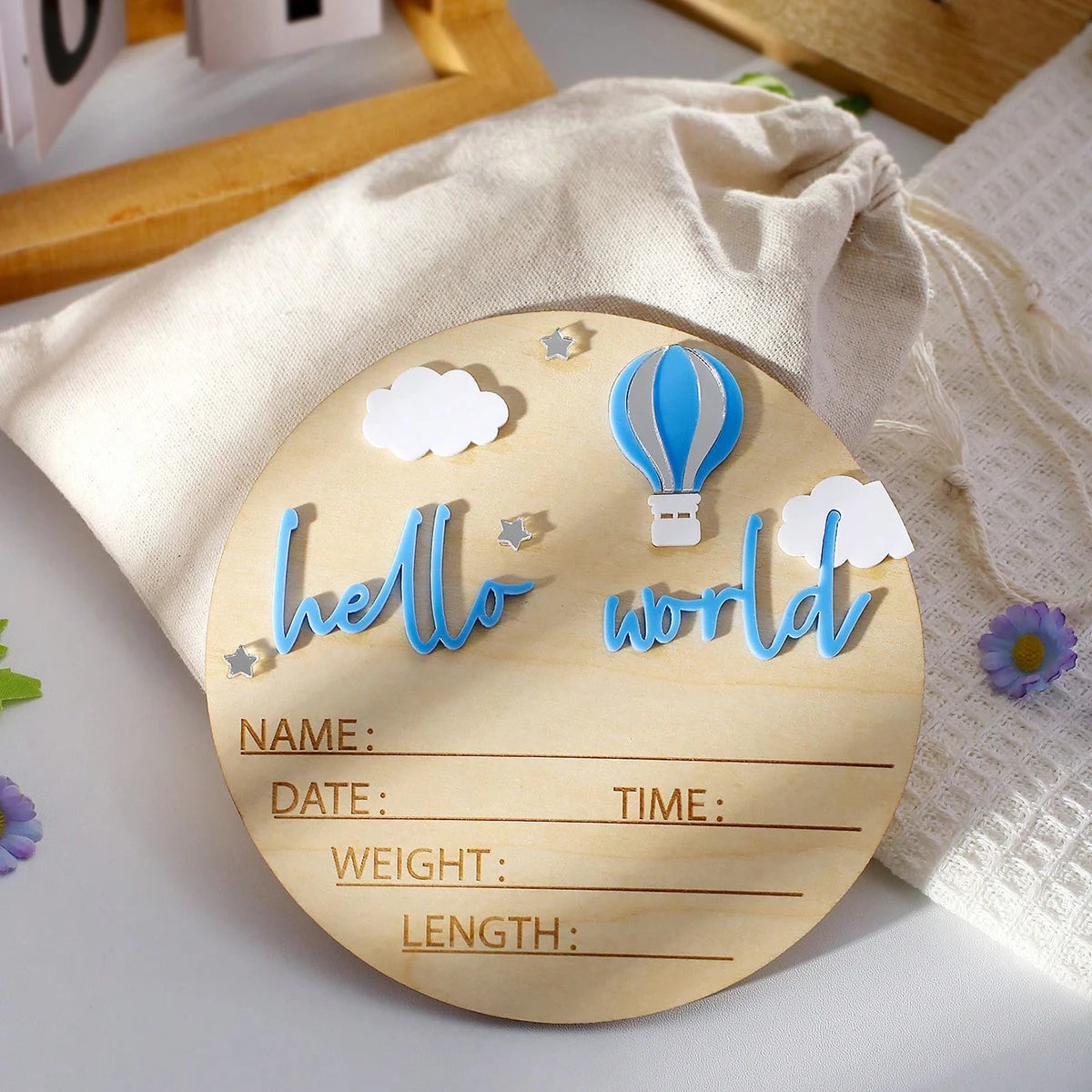 A wooden birth announcement sign with the text hello world and blank lines for name date time weight and length is displayed 
