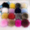 Collection de pompons en fausse fourrure colorés, incluant noir, jaune, blanc, violet, bleu et rose.