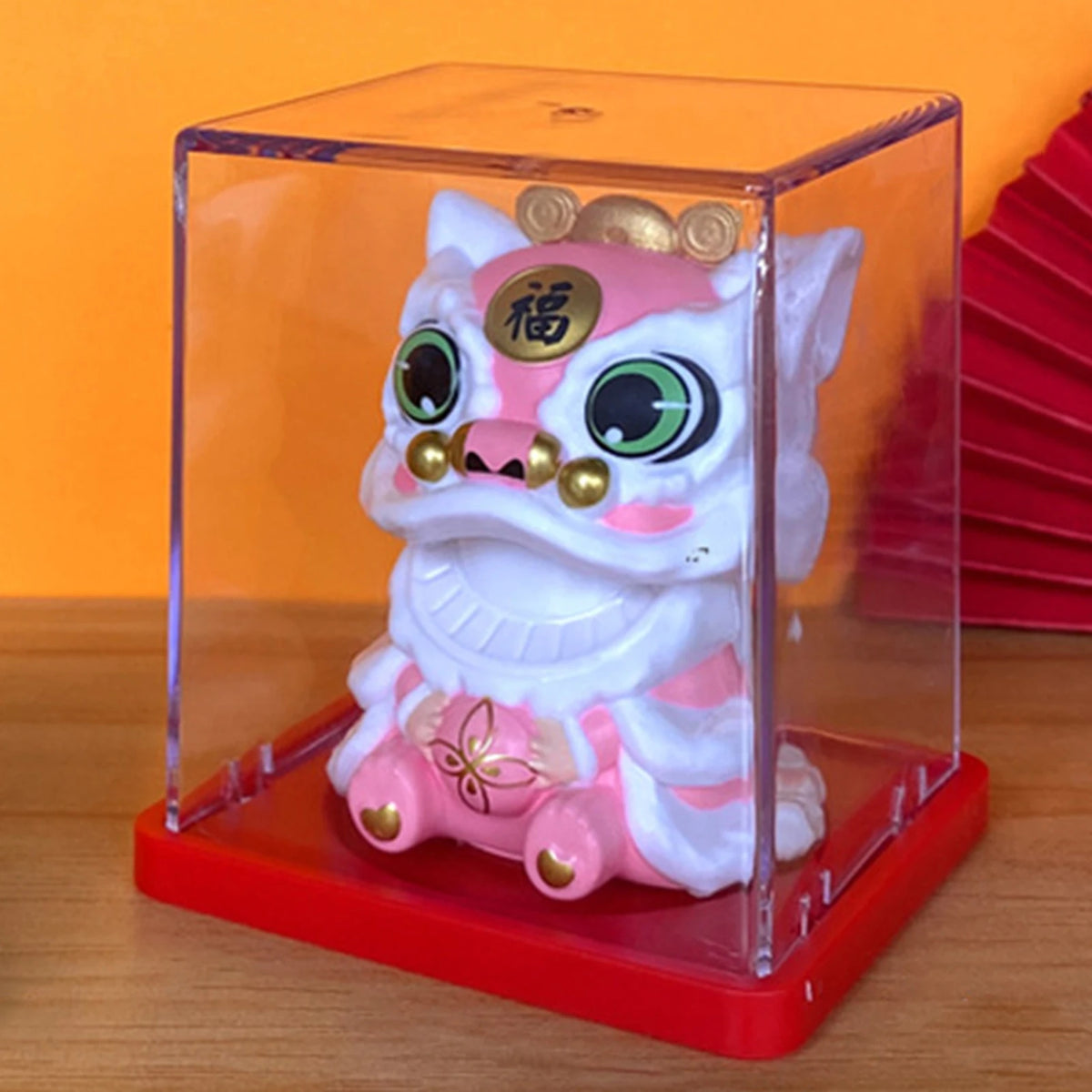 A white and pink solar-powered waving lucky cat figurine displayed in a clear box on a red base.
