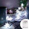 String lights shaped like stars illuminating a festive scene on a plaid cloth.
