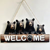 Four black bear figures on a rustic wooden sign that reads Welcome Me