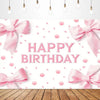 Pink bow tie birthday party backdrop banner with scattered pink confetti and wooden surface