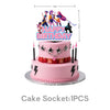 A pink birthday cake with anime hunter girl toppers featuring characters and spark effects.