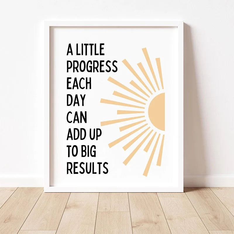 A framed print with the quote A little progress each day can add up to big results featuring a sunburst design.