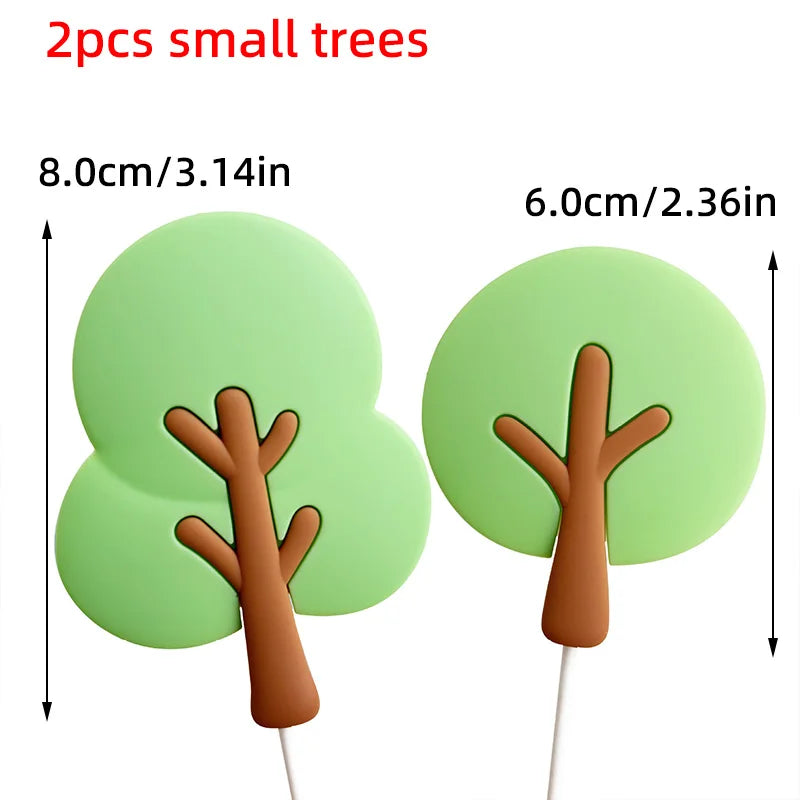 Two small green tree cake toppers with brown branches on white sticks