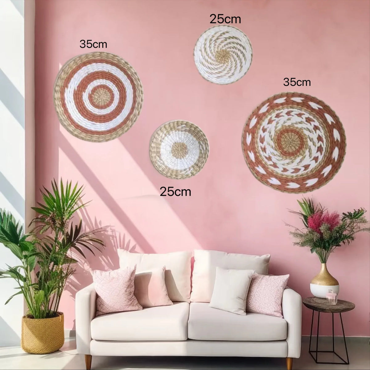 A pink wall decorated with three round woven straw wall hangings of varying sizes and shades.