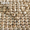 Gros plan de petites citrouilles en résine sculptées dans des tons beige et marron pour la décoration d'Halloween extérieure.