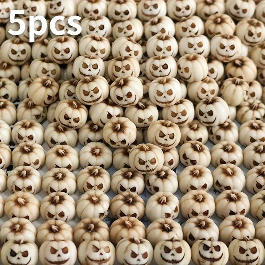 Gros plan de petites citrouilles en résine sculptées dans des tons beige et marron pour la décoration d'Halloween extérieure.