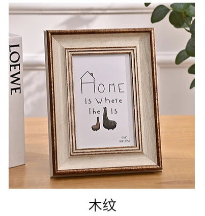 A framed wooden sign with the text Home is Where The Is and a silhouette of a shoe.