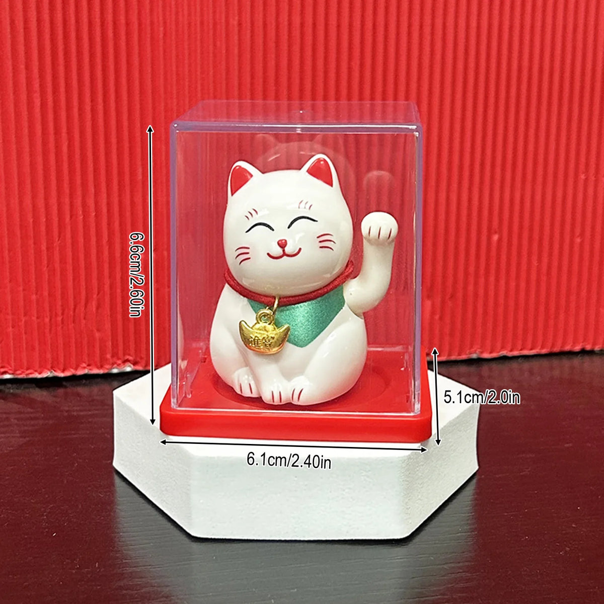 A white ceramic lucky cat figurine with a red collar and gold bell is displayed inside a clear acrylic box.
