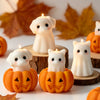 White silicone candle molds shaped like cute ghosts, cats, dogs, and pumpkins displayed on a white surface.