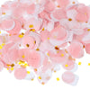 Pink and white round tissue paper confetti dots scattered across a surface.