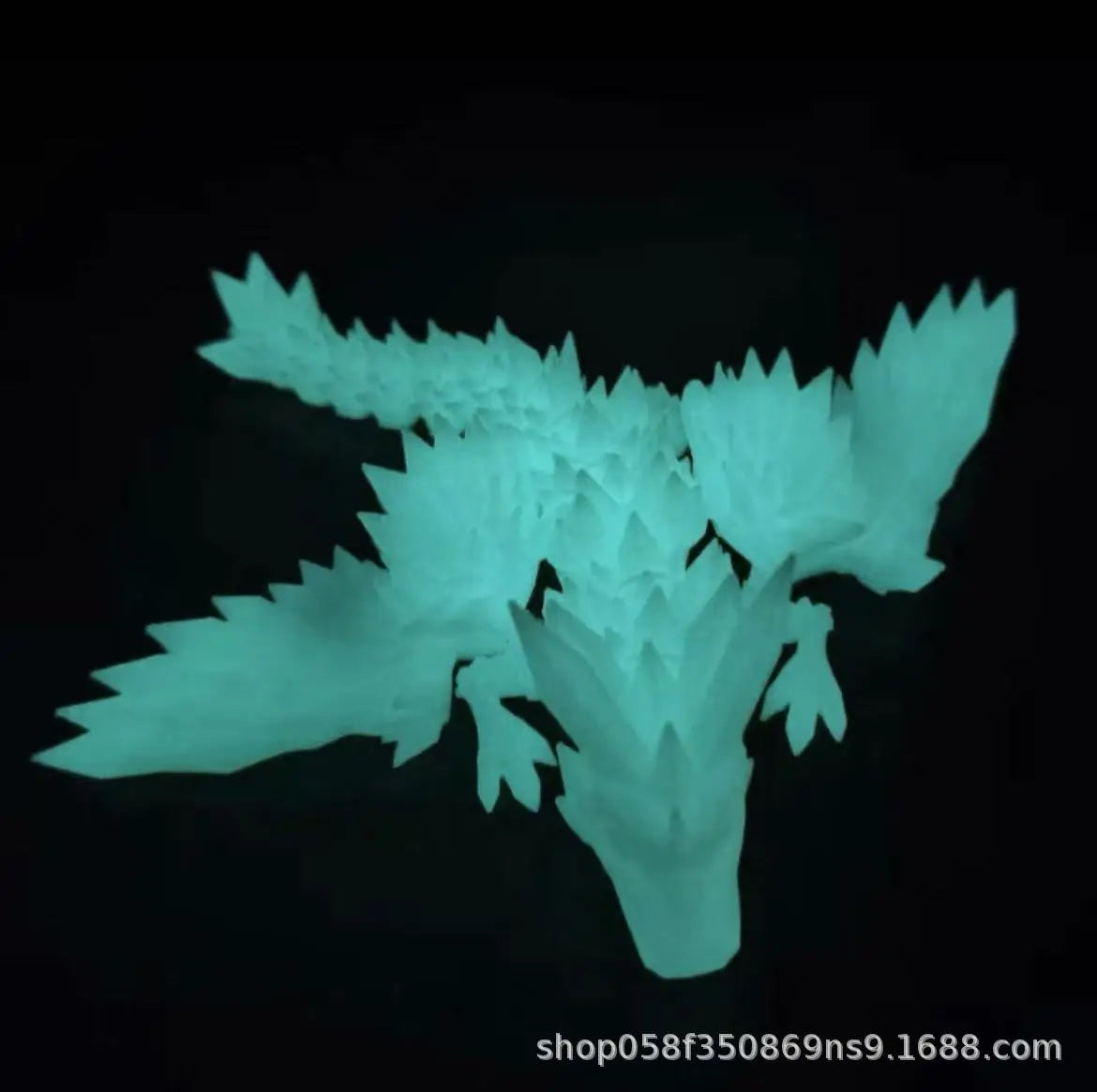 A light cyan 3D printed articulated dragon fidget figurine displayed against a black background.