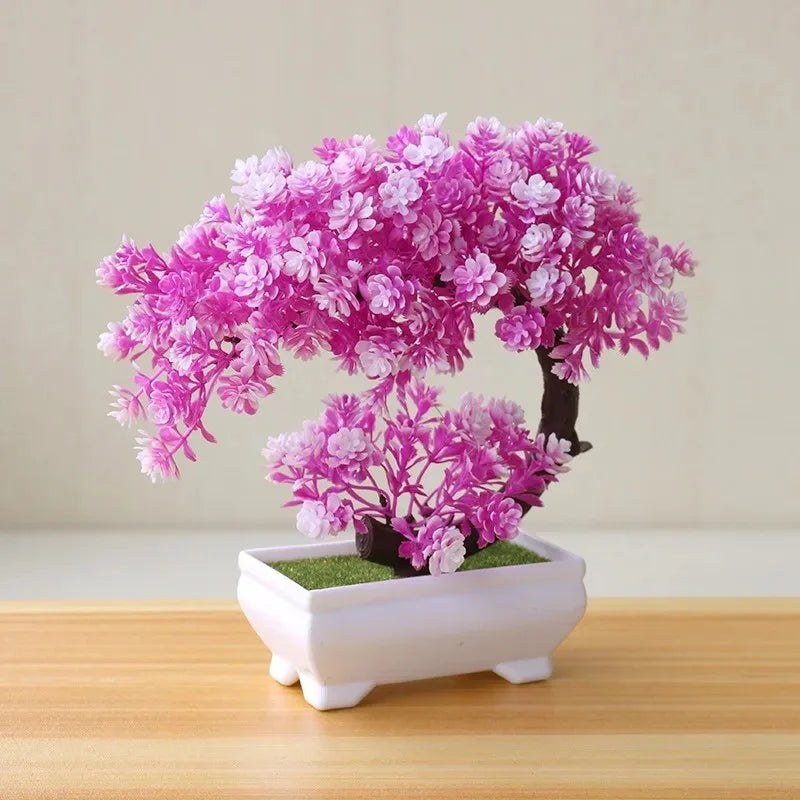 A vibrant pink and white artificial bonsai tree decoration planted in a white rectangular pot.