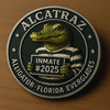 A collectible coin featuring a green alligator head wearing a striped shirt, with the text Alcatraz and Alligator Florida Eve