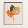 Wall art featuring large, stylized botanical leaves in shades of green and orange on a neutral background.