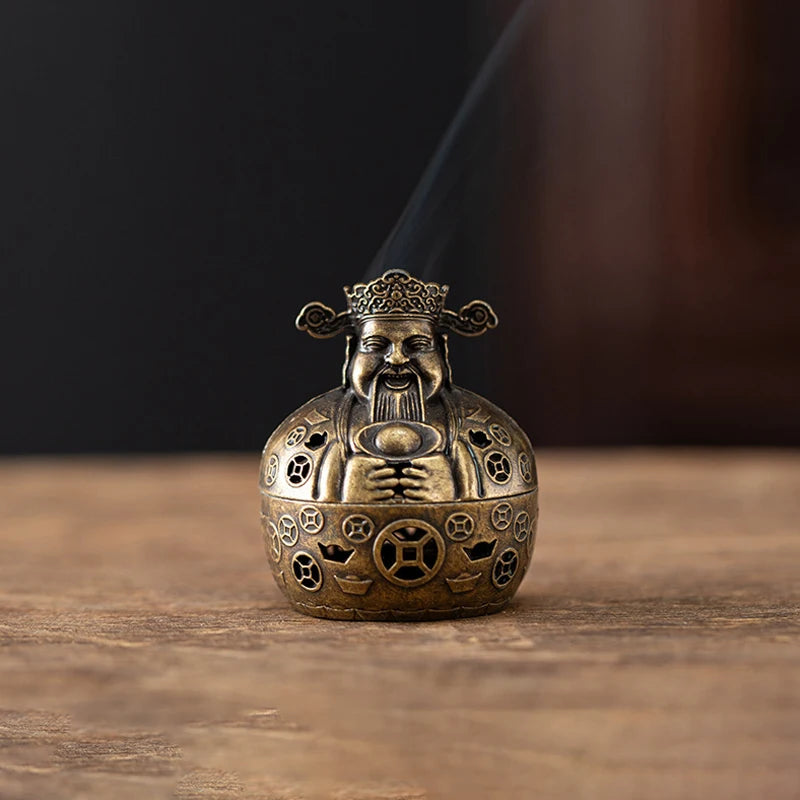 A vintage brass incense burner holder with a dragon face emitting smoke on a wooden surface.