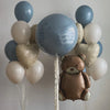 A cluster of light blue and white foil balloons shaped like a teddy bear.
