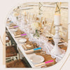 Elegant paper hand fans displayed on a table with gift bags and thank you cards.