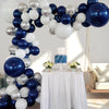 A balloon garland arch featuring navy blue, silver, and white balloons decorating a display table.