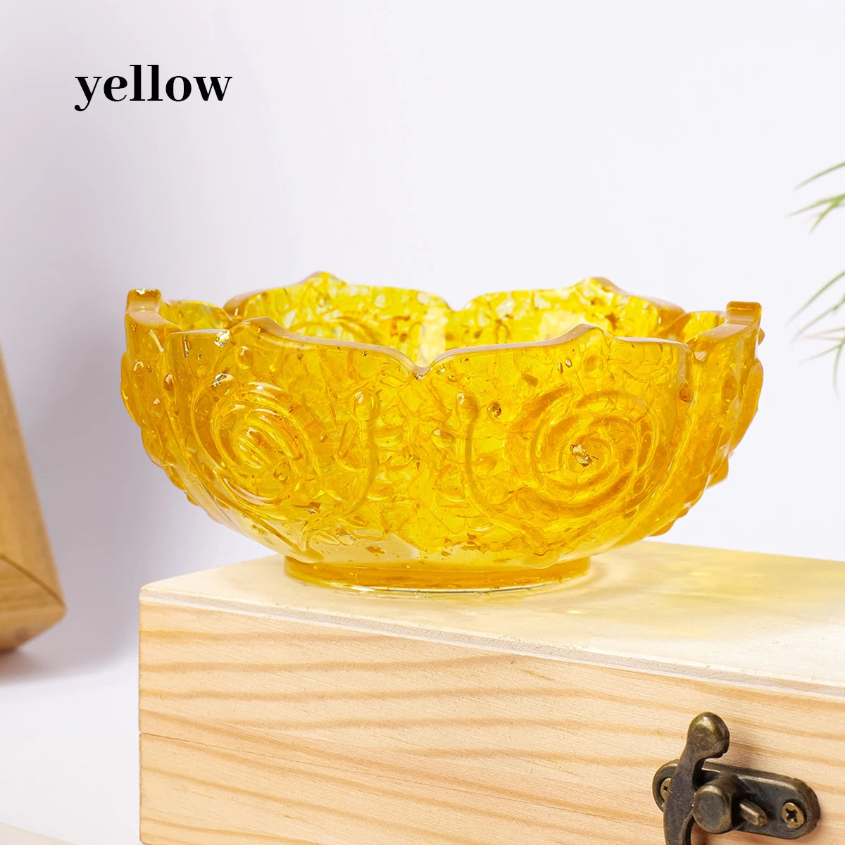 A bright yellow natural crystal lotus bowl resting on a light wooden surface.