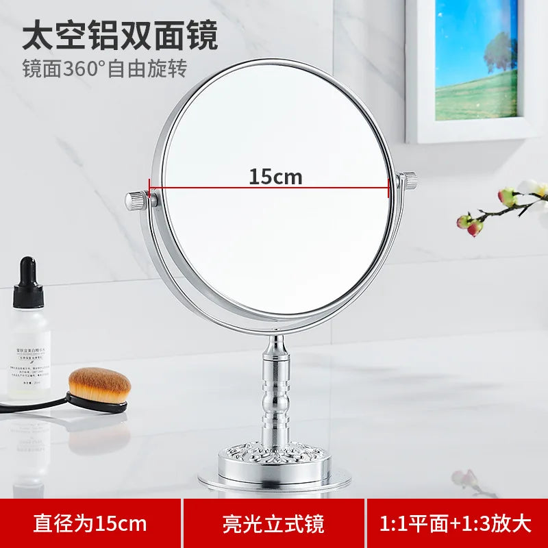 A round silver folding double-sided wall mirror with telescopic arms shown on a white marble surface.