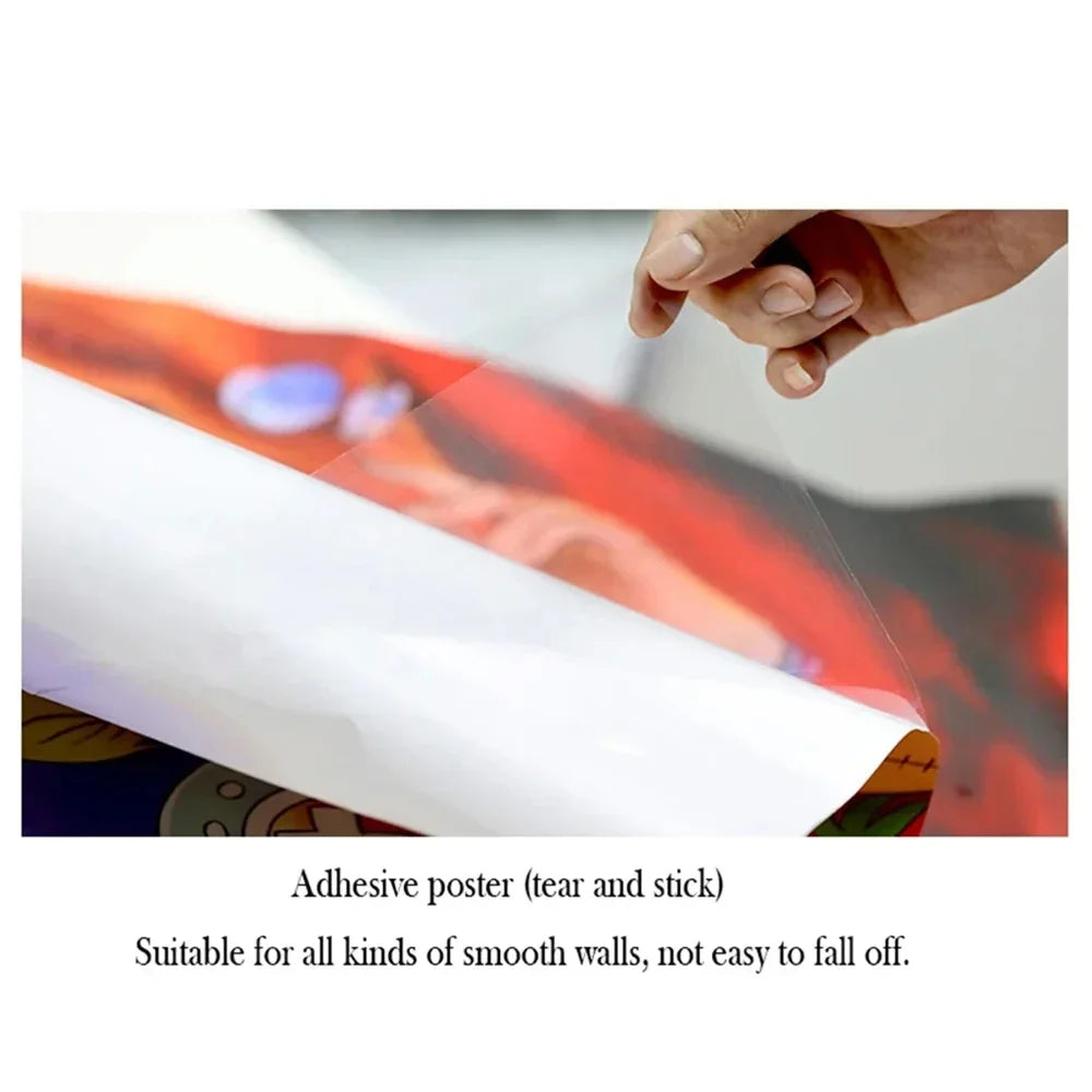 A hand is applying an adhesive poster to a smooth wall surface.