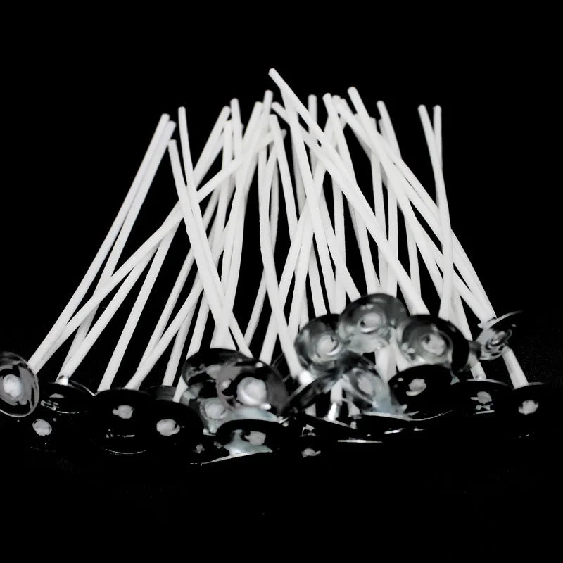 A bundle of white smokeless cotton candle wicks arranged in a fan shape on a dark surface.