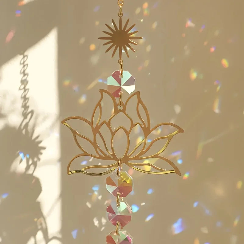 A delicate gold lotus flower suncatcher with hanging prism beads and a star-shaped charm.
