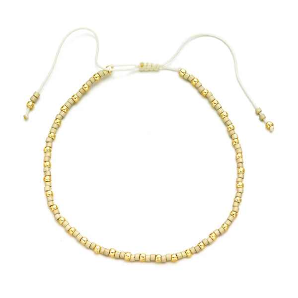 Handmade boho glass bead bracelet with adjustable cord featuring small gold beads.
