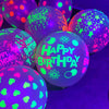 Nahaufnahme von leuchtenden Latexballons in Lila- und Grüntönen mit Geburtstagstext.