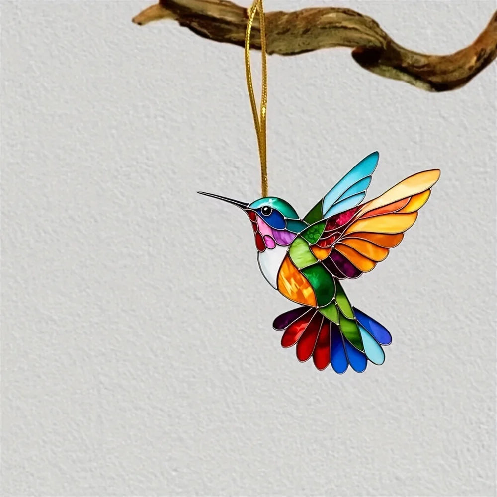 A colorful acrylic hummingbird suncatcher ornament hanging from a gold cord.