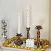 A vintage resin wall sconce candle holder with a white pillar candle and decorative brass accents.