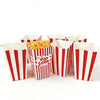 Several red and white striped paper boxes filled with popcorn are displayed on a white surface.