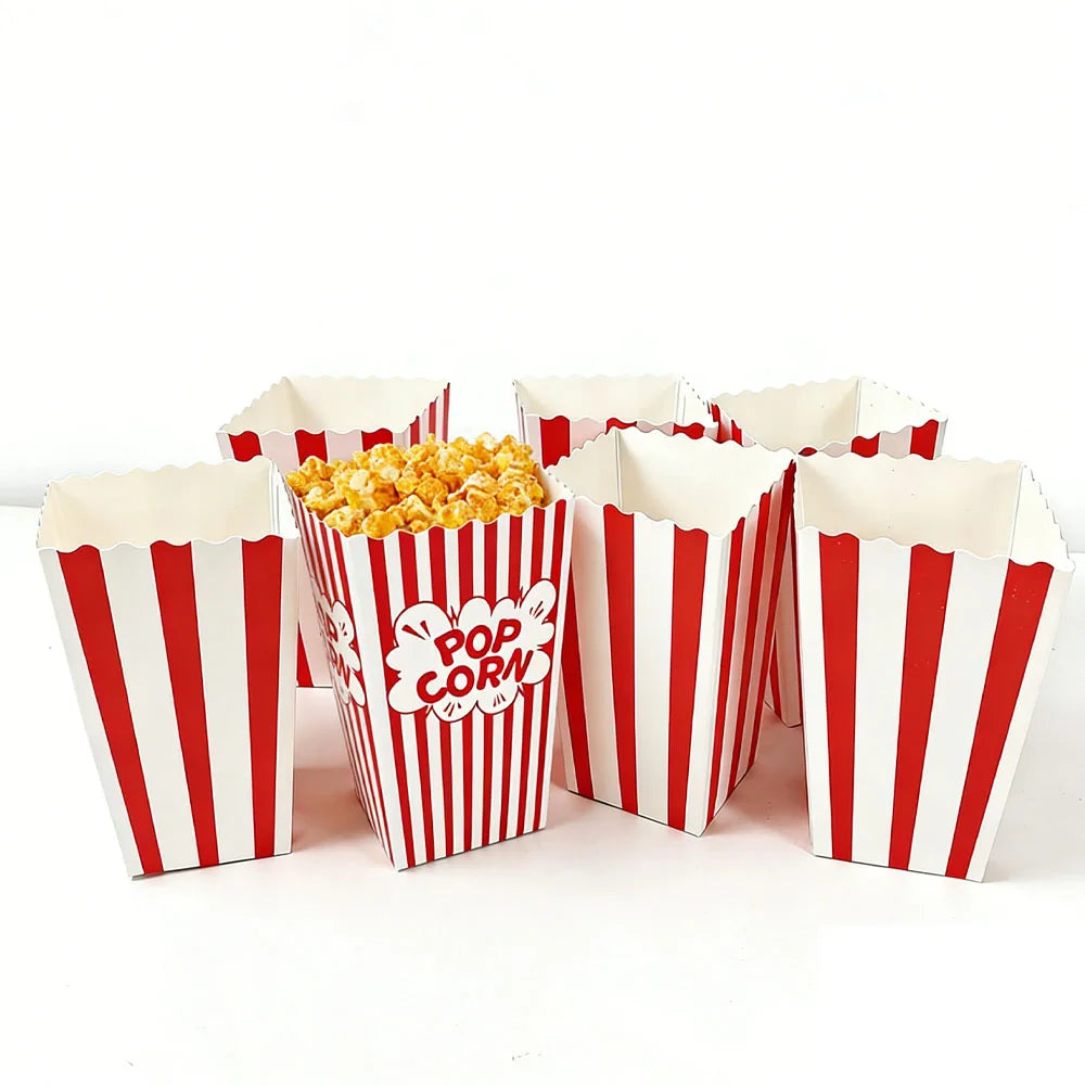 Several red and white striped paper boxes filled with popcorn are displayed on a white surface.