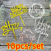 A set of ten acrylic birthday cake toppers in pink and gold colors displayed on a wooden background.