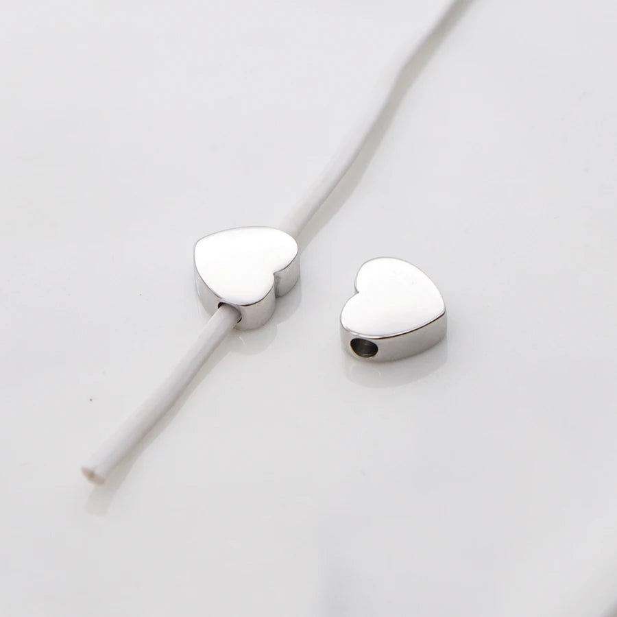Silver heart-shaped stainless steel bead charms with a thin wire for jewelry making