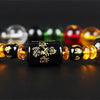 A bracelet made of polished crystal beads in various colors including black, yellow, red, and green.