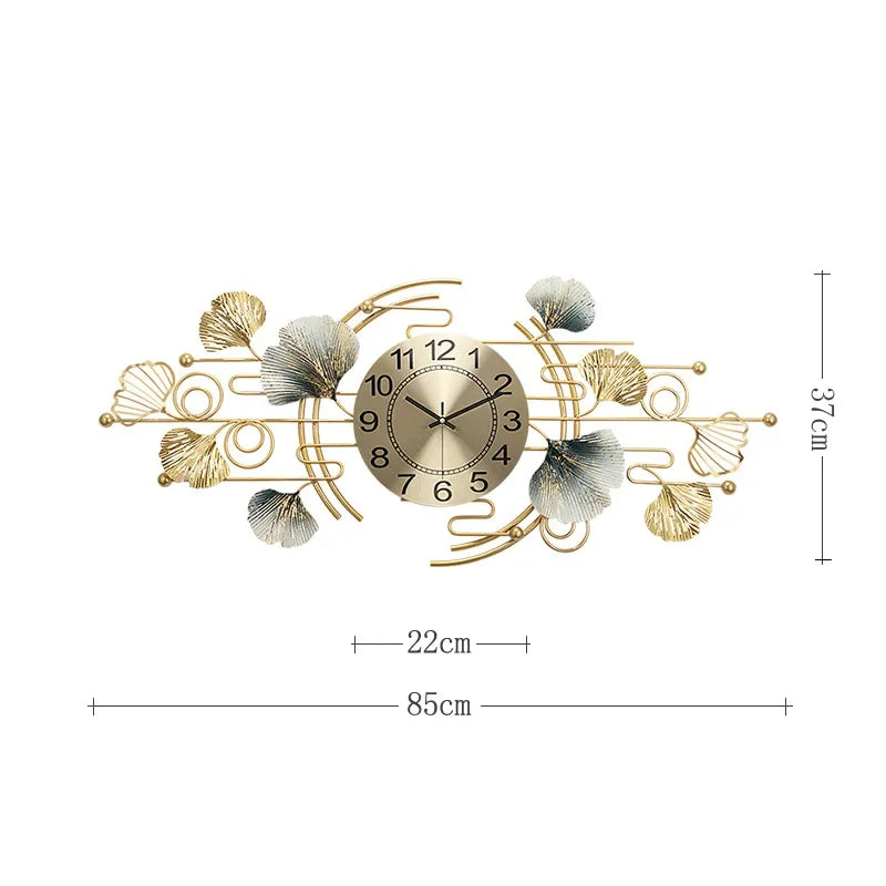 A round metal wall clock featuring decorative leaves resembling ginkgo foliage in gold and silver tones.