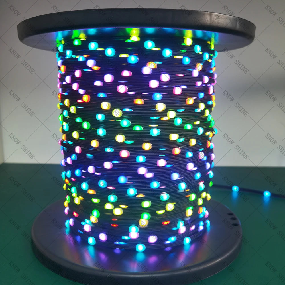 A close-up of a coil of 12V addressable LED string lights with backup data line glowing brightly.
