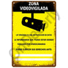A yellow metal sign with black text warning that the area is video-surveilled by cameras under organic law.