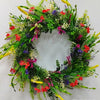 A wreath of artificial wildflowers featuring red, purple, yellow, and green foliage for spring and summer decor.