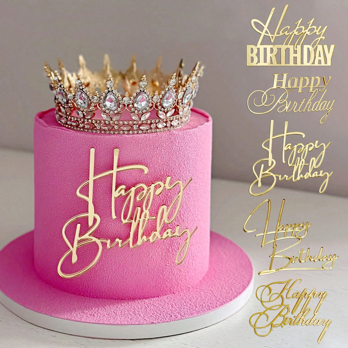 A pink birthday cake with a gold acrylic crown topper and gold script writing on the side.