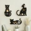 A black cat wall shelf display featuring candles, crystals, and gold accents against a light wall.