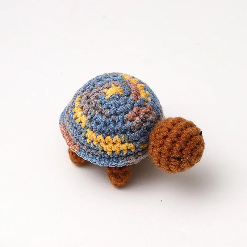 Handmade crocheted turtle plush with blue and yellow patterned shell and brown body