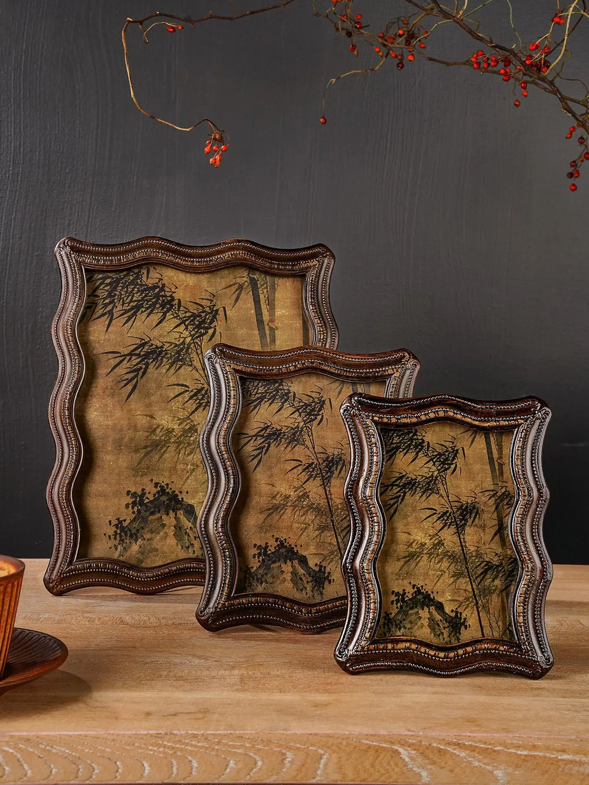 A set of three vintage resin photo frames with distressed gold and dark brown wood accents displayed on a wooden surface.