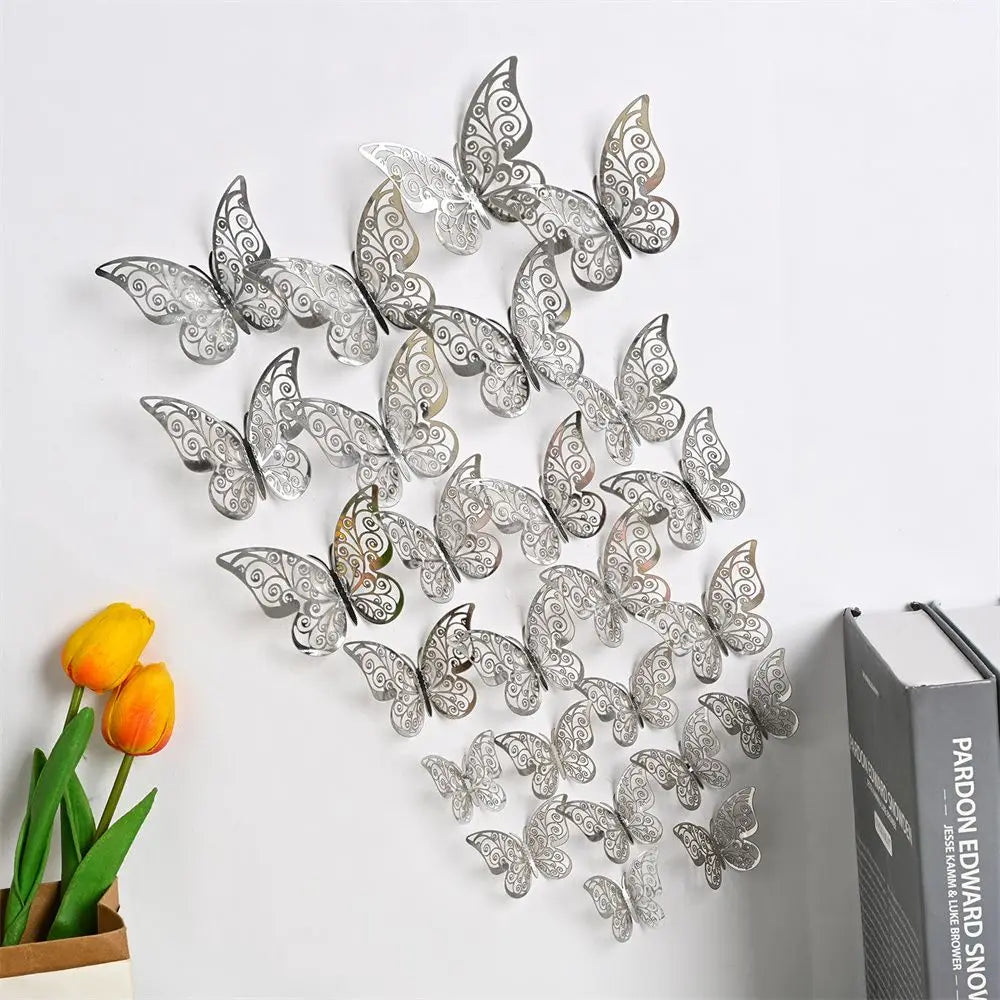 Silver 3D hollow butterfly wall decals set displayed on a white wall next to a book.